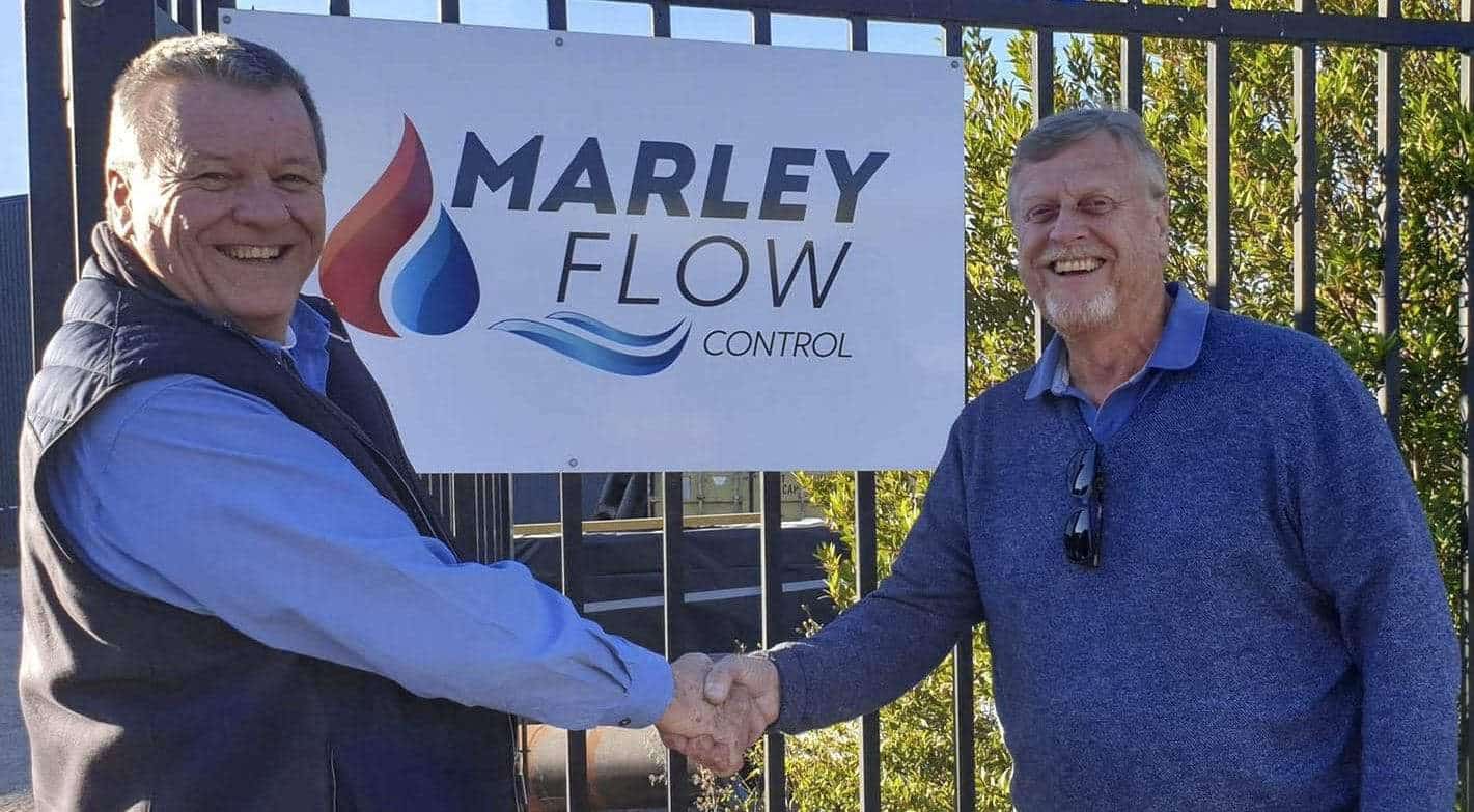 Gareth Jones and Willem Kars shaking hands out side of one of Marley Flow Control's sites after signing the contract to complete Marley Flow Control's acquisition of The Cooling Tower Company